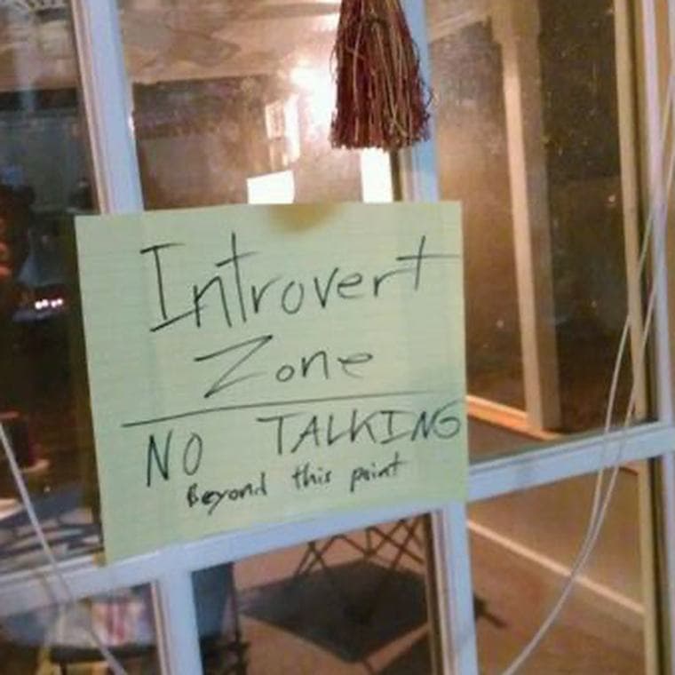 A handwritten sign taped to a glass door reading Introvert Zone
